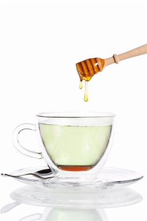simsearch:400-06387884,k - honey drops from a honey dipper in glass cup with green tea on white background Stock Photo - Budget Royalty-Free & Subscription, Code: 400-04375008