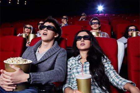 Young people in 3D glasses hard watching a movie at the cinema Stock Photo - Budget Royalty-Free & Subscription, Code: 400-04375716