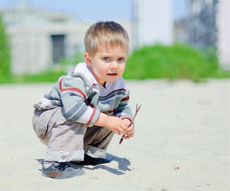 The cute boy plaing on a sand Stock Photo - Budget Royalty-Free & Subscription, Code: 400-04376408