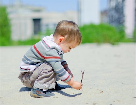 The cute boy plaing on a sand Foto de stock - Super Valor sin royalties y Suscripción, Código: 400-04376409