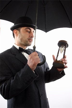 man with bowler hat ,  umbrella  and hour- glass Foto de stock - Super Valor sin royalties y Suscripción, Código: 400-04376659