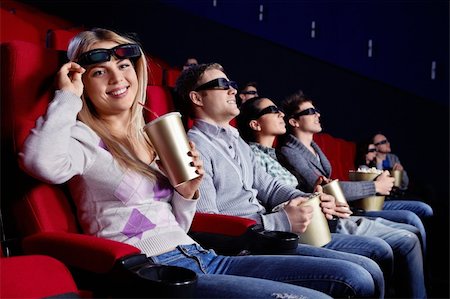 Attractive girl looks into the camera from under the 3d glasses at the cinema Stock Photo - Budget Royalty-Free & Subscription, Code: 400-04377567