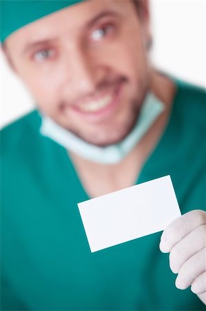 A young surgeon with a blank business card on a white background Stock Photo - Budget Royalty-Free & Subscription, Code: 400-04377712