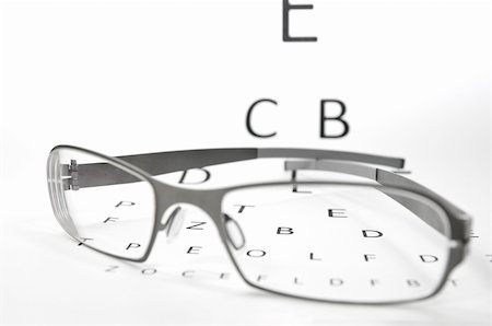 endhals (artist) - pair of glasses lying on an eyesight test Fotografie stock - Microstock e Abbonamento, Codice: 400-04378249