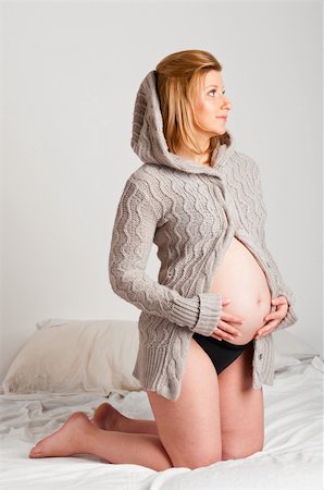 simsearch:400-04859723,k - fashionable pregnant woman wearing woolen cardigan is looking sideways Fotografie stock - Microstock e Abbonamento, Codice: 400-04378943