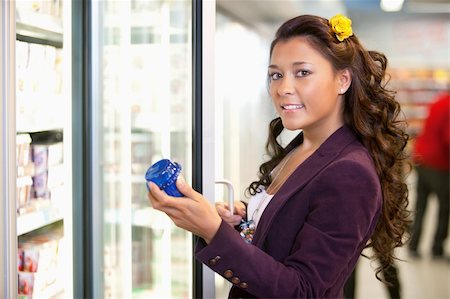 simsearch:400-04379121,k - Portrait of a young woman holding container in front of refrigerator in the supermarket Stock Photo - Budget Royalty-Free & Subscription, Code: 400-04379105