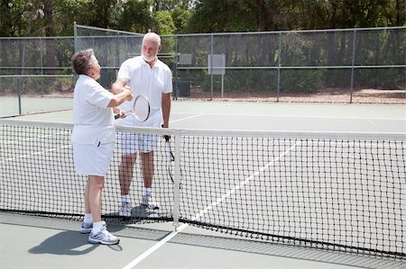 Senior tennis players shake hands over the net.  Wide shot with room for text. Stock Photo - Budget Royalty-Free & Subscription, Code: 400-04379427
