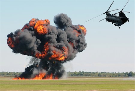 Military helicopter flying over ground explosion Stock Photo - Budget Royalty-Free & Subscription, Code: 400-04370559