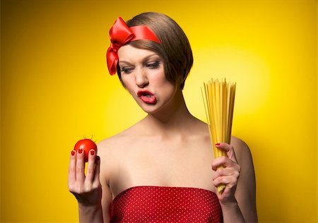 retro wife cooking - Portrait of young housewife holding potato and pasta in her hands. Retro styled. Isolated on yellow background Stock Photo - Budget Royalty-Free & Subscription, Code: 400-04370590