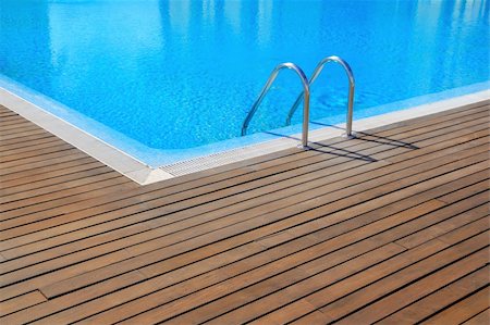 blue swimming pool with teak wood flooring stripes summer vacation Fotografie stock - Microstock e Abbonamento, Codice: 400-04370927