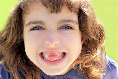 indented little girl sticking tongue between teeth smiling portrait Stock Photo - Budget Royalty-Free & Subscription, Code: 400-04370944