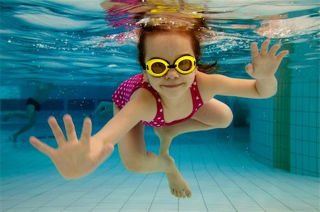 The little girl in the water park swimming underwater and smiling Stock Photo - Budget Royalty-Free & Subscription, Code: 400-04371036