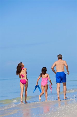 Rear view of a happy family of mother, father and child, a daughter, running holding hands and having fun in the waves of a sunny beach Stock Photo - Budget Royalty-Free & Subscription, Code: 400-04371476