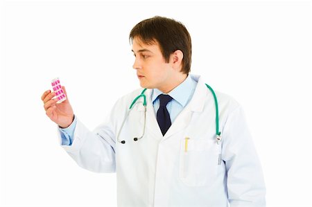 simsearch:400-07099832,k - Concentrated medical doctor looking on pills pack isolated on white Stock Photo - Budget Royalty-Free & Subscription, Code: 400-04371559