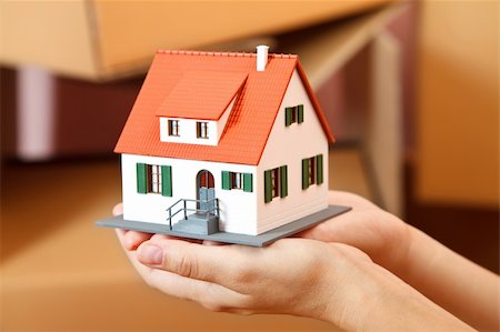 roof and hands - Model house in woman's hand, boxes in the background Stock Photo - Budget Royalty-Free & Subscription, Code: 400-04372037