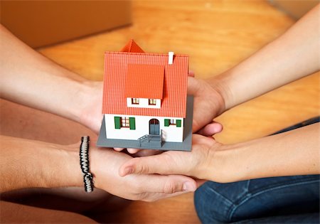 roof and hands - Model house in hand of a couple, boxes in the background Stock Photo - Budget Royalty-Free & Subscription, Code: 400-04372042