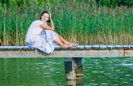 Young Woman sitting on a pier and looking at the water. Stock Photo - Budget Royalty-Free & Subscription, Code: 400-04373091