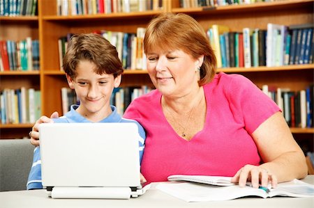 Mother (or teacher) helps her young son study on a computer in the library. Stock Photo - Budget Royalty-Free & Subscription, Code: 400-04373191