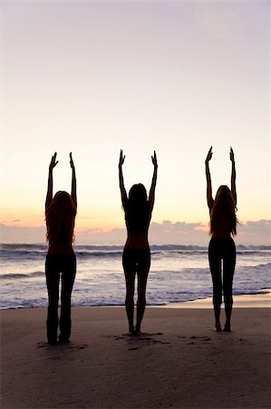 Three young women in a warrior position practicing yoga on a beach at sunrise or sunset Stock Photo - Budget Royalty-Free & Subscription, Code: 400-04373201