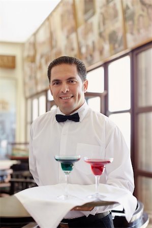 simsearch:693-03783029,k - hispanic waiter serving adult couple at table in restaurant and looking at camera. Horizontal shape, front view, waist up Stockbilder - Microstock & Abonnement, Bildnummer: 400-04384199