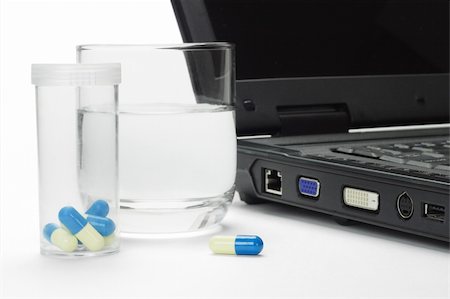 Pills and glass of water next to laptop - conceptual image of IT work related stress Photographie de stock - Aubaine LD & Abonnement, Code: 400-04384713