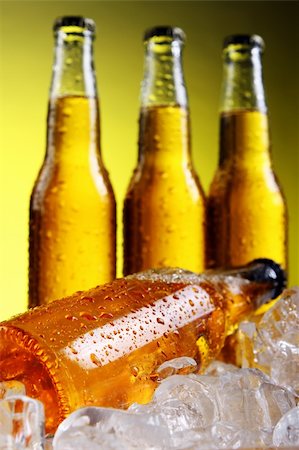 simsearch:400-04392468,k - Bottles of cold and fresh beer with ice over yellow background Photographie de stock - Aubaine LD & Abonnement, Code: 400-04384973