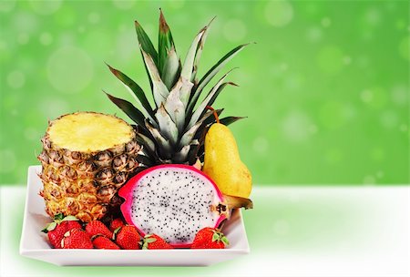 pineapple growing - Welcome to the tropics: tropical fresh fruits served in a white plate on fun green background. Stock Photo - Budget Royalty-Free & Subscription, Code: 400-04384985