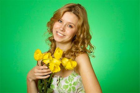 HappyClose up on a green background Happy young woman hugging a yellow tulip. Young Woman Hugging Flower Stock Photo - Budget Royalty-Free & Subscription, Code: 400-04385283