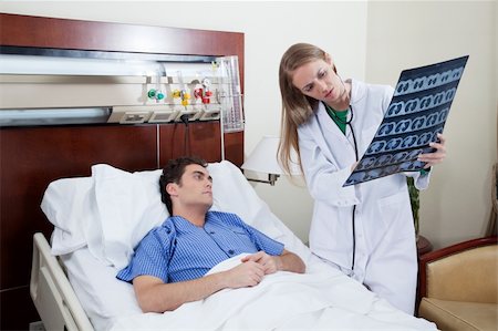 doctor showing results to patient - Female doctor showing chest x-ray report to a male patient Stock Photo - Budget Royalty-Free & Subscription, Code: 400-04386474