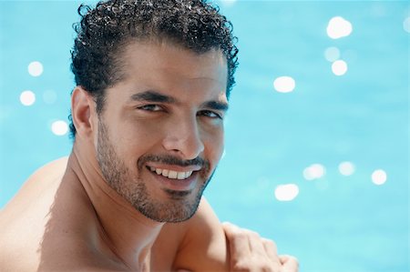 simsearch:400-04391064,k - Handsome happy young hispanic man smiling and relaxing near hotel pool. Horizontal shape, head and shoulders, copy space Stock Photo - Budget Royalty-Free & Subscription, Code: 400-04386587