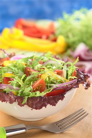 simsearch:400-05326972,k - Fresh mixed salad from red-leaf lettuce, curly endive (frisee), cherry tomato, red onion, cucumber and red and yellow bell pepper in white bowl with fork in front and ingredients in the back (Selective Focus, Focus on the tomato in the front) Foto de stock - Super Valor sin royalties y Suscripción, Código: 400-04388128