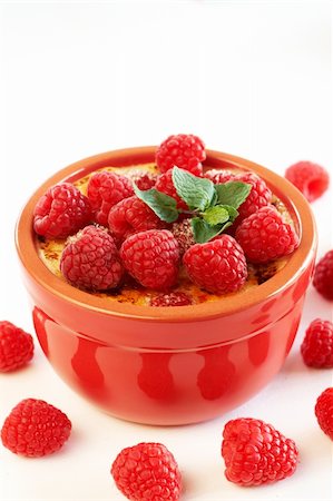 French creme brulee dessert with raspberries and mint covered with caramelized sugar in red terracotta ramekin on white background Stock Photo - Budget Royalty-Free & Subscription, Code: 400-04389925