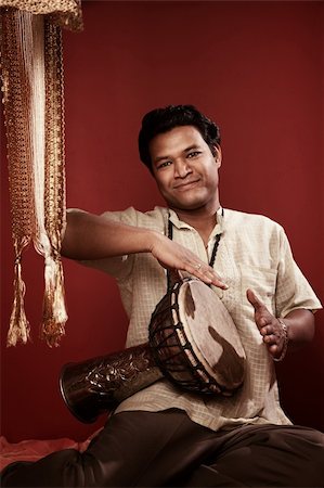 Smiling young Indian man playing a tabla Stock Photo - Budget Royalty-Free & Subscription, Code: 400-04380545