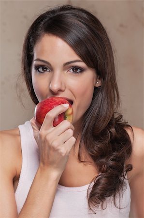 Portrait of beautiful young woman eating an apple Stock Photo - Budget Royalty-Free & Subscription, Code: 400-04381711