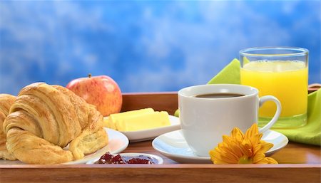 Delicious breakfast on tray consisting of coffee, orange juice, apple, croissants, jam and butter (Selective Focus, Focus on the front) Fotografie stock - Microstock e Abbonamento, Codice: 400-04381964