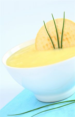 soup and crackers - Fresh potato cream soup garnished with a cracker and chives on bluish background (Selective Focus, Focus on the cracker and the chives) Stock Photo - Budget Royalty-Free & Subscription, Code: 400-04381976