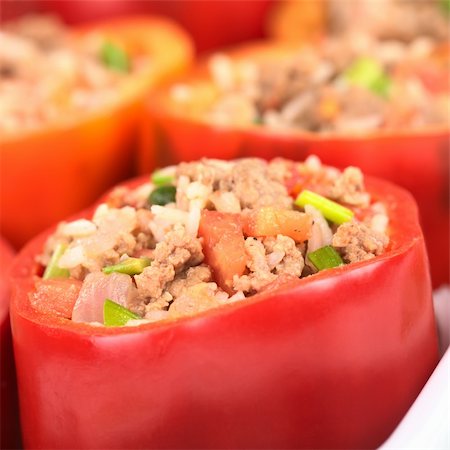 Stuffed red bell pepper filled with minced meat, onion, rice, tomato and green onion in a casserole (Selective Focus, Focus on the tomato piece in the front and the stuffing around it) Stock Photo - Budget Royalty-Free & Subscription, Code: 400-04381984