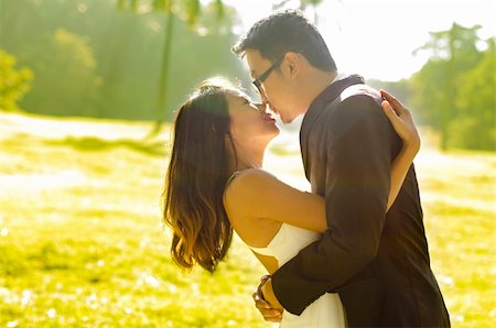 simsearch:400-04382275,k - Bride and groom kissing in the park, back-lit in the morning. Stock Photo - Budget Royalty-Free & Subscription, Code: 400-04382275