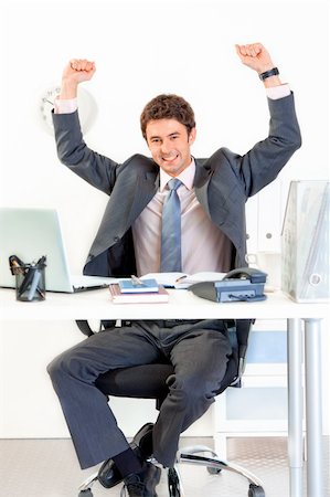 simsearch:400-06639907,k - Excited modern businessman sitting at office desk and rejoicing his success Stock Photo - Budget Royalty-Free & Subscription, Code: 400-04382798