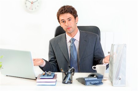 simsearch:400-05900668,k - Confused modern business man sitting at office desk Stock Photo - Budget Royalty-Free & Subscription, Code: 400-04382790