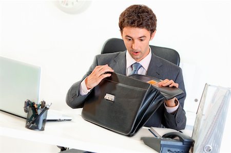 simsearch:400-06639907,k - Shocked modern businessman sitting at office desk and looking in briefcase Stock Photo - Budget Royalty-Free & Subscription, Code: 400-04382808