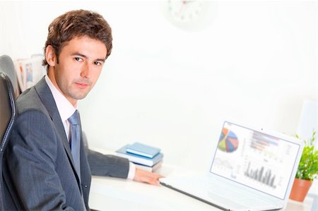 simsearch:400-06639907,k - Serious modern businessman sitting at office desk with laptop Stock Photo - Budget Royalty-Free & Subscription, Code: 400-04382813