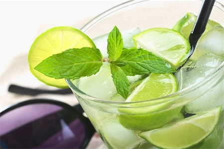 simsearch:659-08939952,k - Mojito cocktail made of white rum, ice cubes, sugar, mint leaves and limes with a black drinking straw and sunglasses in the back (Selective Focus, Focus on the front of the mint leaf) Photographie de stock - Aubaine LD & Abonnement, Code: 400-04394338