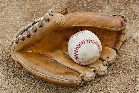 An old worn baseball in a baseball glove on a field Photographie de stock - Aubaine LD & Abonnement, Code: 400-04394502