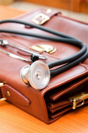 Doctor's case with stethoscope against wooden background Stock Photo - Budget Royalty-Free & Subscription, Code: 400-04394977