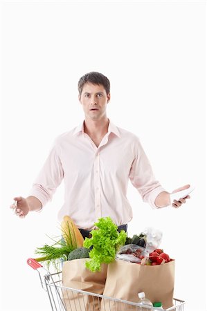 shopaholic (male) - Surprised man with a cart with food on a white background Stock Photo - Budget Royalty-Free & Subscription, Code: 400-04395974