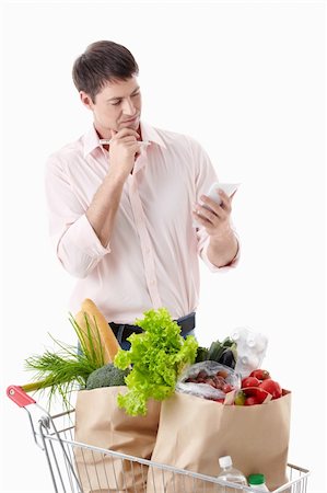 shopaholic (male) - A thoughtful man with a cart with food on a white background Stock Photo - Budget Royalty-Free & Subscription, Code: 400-04395973