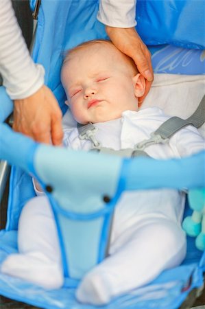 simsearch:400-06076022,k - Mother's hand stroking  head sleeping  in stroller baby girl Photographie de stock - Aubaine LD & Abonnement, Code: 400-04396159