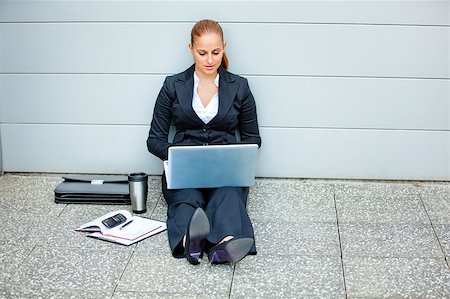 Pensive modern business woman sitting on floor at office building  and using laptop Stock Photo - Budget Royalty-Free & Subscription, Code: 400-04396699