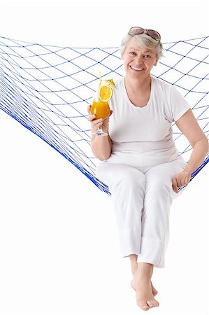 Mature woman with a cocktail in a hammock isolated Stock Photo - Budget Royalty-Free & Subscription, Code: 400-04398300